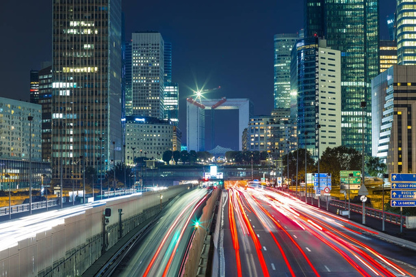 Mrakodrapy v pařížské obchodní čtvrti La Défense. Evropská noc panoráma s dynamickým ulice dopravní, světla auta a prosklených fasád moderních budov. Ekonomika, finance, dopravní koncepci. Tónovaný - Fotografie, Obrázek