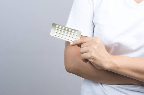 Confezione di pillole contraccettive da donna, medicina anticoncezionale su sfondo grigio
 - Foto, immagini