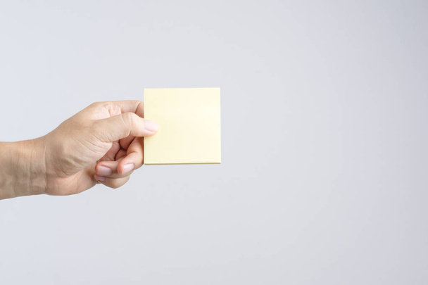 Hoja de papel pegajosa de la nota del poste de la mano sobre fondo blanco
 - Foto, Imagen