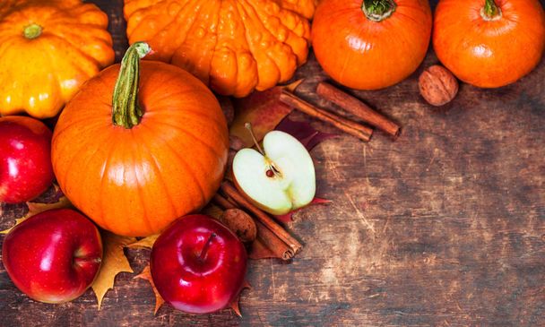 Harvest or Thanksgiving background with pumpkins, apples and fallen leaves on wooden background  with copyspace. Halloween, Thanksgiving day or seasonal autumnal concep - Фото, изображение