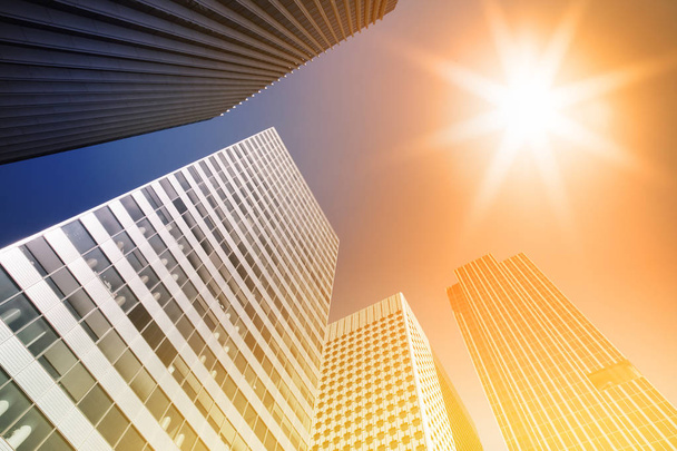 Wolkenkrabber glazen gevels op een zonnige dag met zonnestralen in de blauwe hemel. Moderne gebouwen in Parijs zakelijke wijk La Defense. Economie, financiën, activiteit bedrijfsconcept. Bottom-up-weergave - Foto, afbeelding