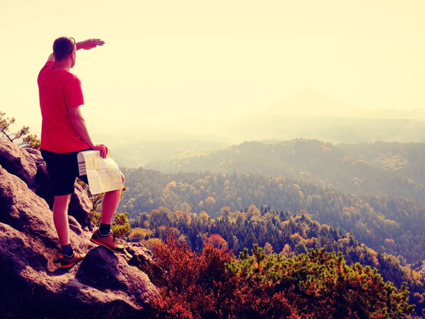 Ztracený turista na vrcholu při pohledu do krajiny, zatímco kontrola papírové mapy, Turistika v přírodě. - Fotografie, Obrázek