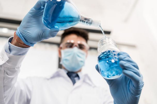 scientist pouring reagent into jar - Фото, изображение