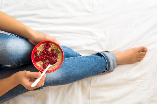 Healthy eating concept. Women's hands holding bowl with muesli and frozen berries. Top view. Lifestyle photo. Toned image - Foto, Imagem