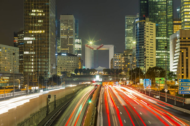 Mrakodrapy v pařížské obchodní čtvrti La Défense. Evropská noc panoráma s dynamickým ulice dopravní, světla auta a prosklených fasád moderních budov. Ekonomika, finance, dopravní koncepci. Tónovaný - Fotografie, Obrázek