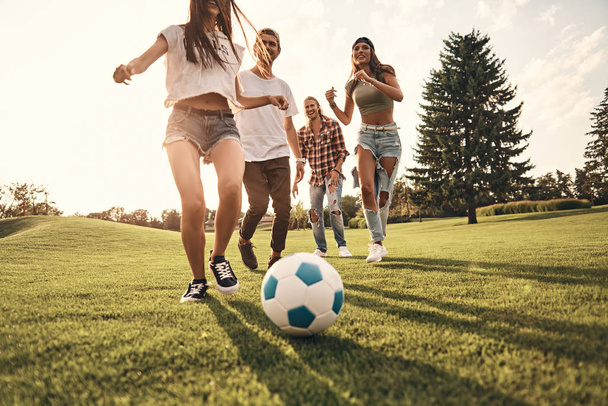 four friends playing soccer - Фото, изображение