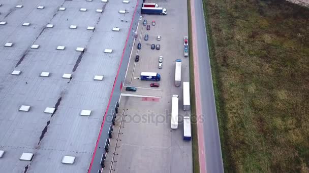 Trucks are Driving to Logistics Center. Aerial Shot./ Storage Building/ Loading Area where Many Trucks Are Loading/ Unloading Merchandise - Footage, Video