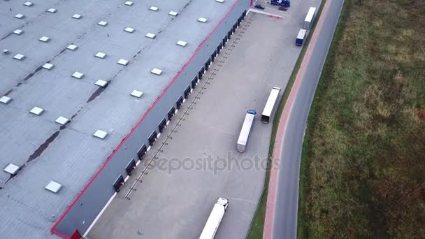 LKW fährt zum Logistikzentrum. Luftaufnahme. / Lagerhalle / Ladefläche, auf der viele LKW Waren be- / entladen - Filmmaterial, Video
