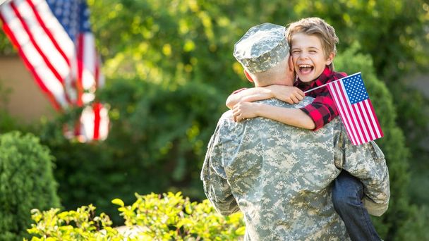 Happy reunion of soldier with family, son hugging his father - Photo, Image