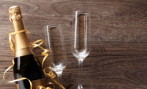 Photo of two wineglasses, bottle of champagne, gold ribbons - Foto, imagen