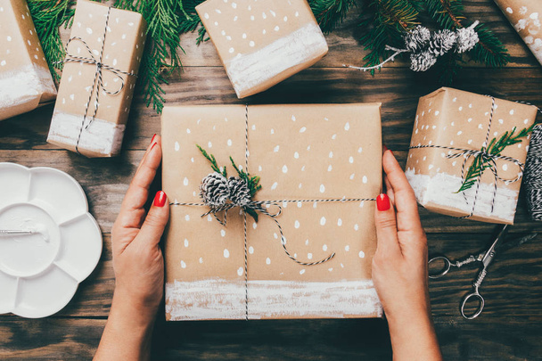 Woman wrapping Christmas presents in a crafty way - Zdjęcie, obraz