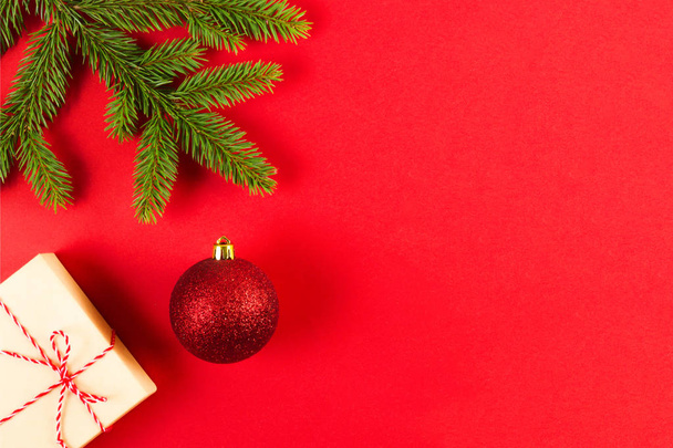 Composição de Natal em fundo vermelho. Ramos de abeto verde, caixa de presente de Natal e decoração
. - Foto, Imagem