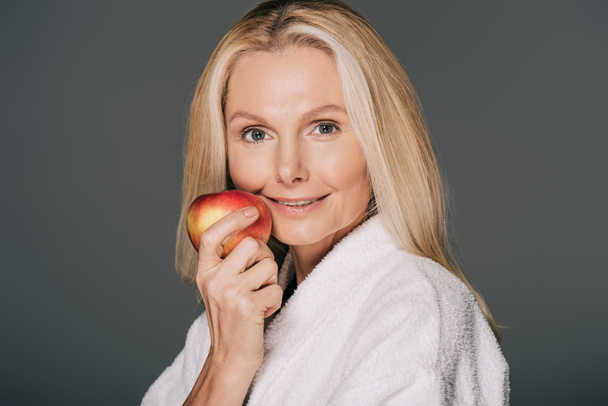 middle aged woman with apple - Φωτογραφία, εικόνα