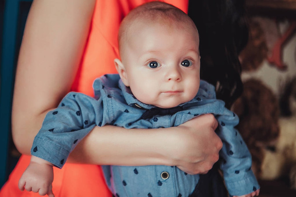 Portret nowo narodzonego dziecka na rękach matki. Na sobie niebieską koszulę, krawat, Spodnie i łuk. Styl życia zbliżenie zdjęcie - Zdjęcie, obraz