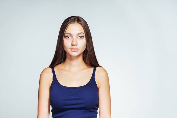 young beautiful girl in blue top and with long hair posing on white background - Fotografie, Obrázek