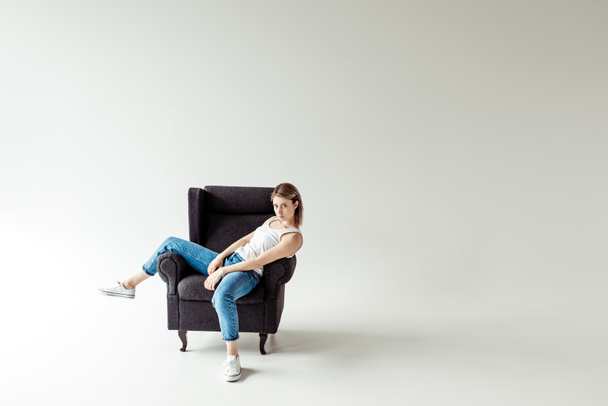 woman in singlet sitting on armchair  - Photo, Image