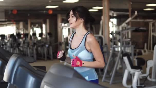 young sporty girl running on the treadmill at the gym. fitness, sports, health - Záběry, video