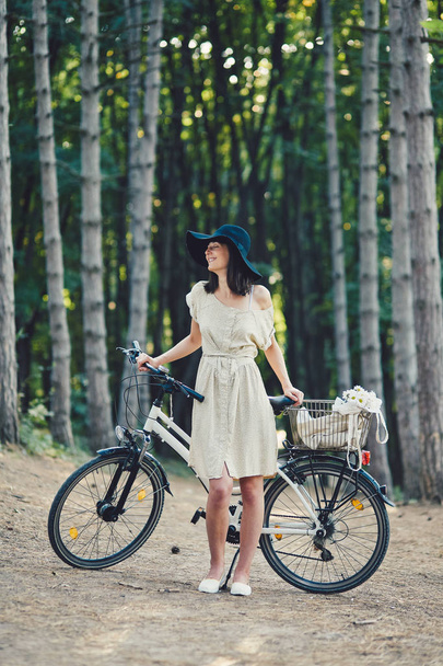 Νεαρή γυναίκα φόντο φύση με ποδήλατο - Φωτογραφία, εικόνα