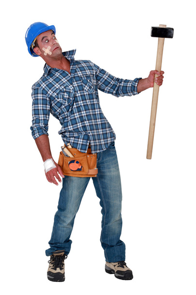 Bandaged construction worker wary of a sledgehammer - Foto, imagen