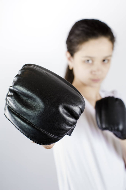 Young woman with boxing gloves. Selective focus. Protection concept - 写真・画像