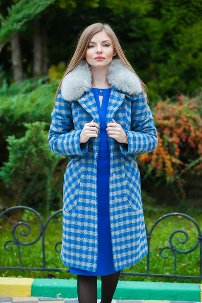 秋の毛皮のコートを身に着けている美しい若いブロンドの女性 - 写真・画像