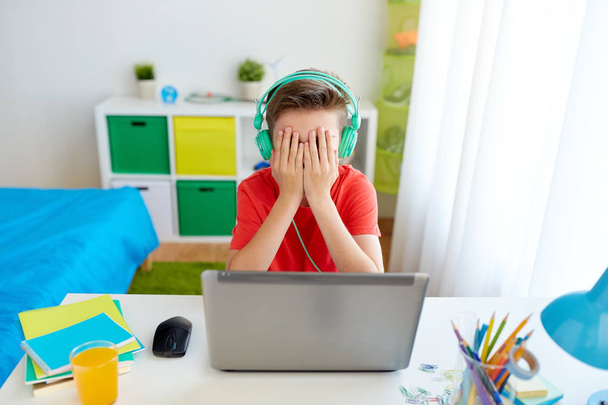 boy in headphones playing video game on laptop - 写真・画像