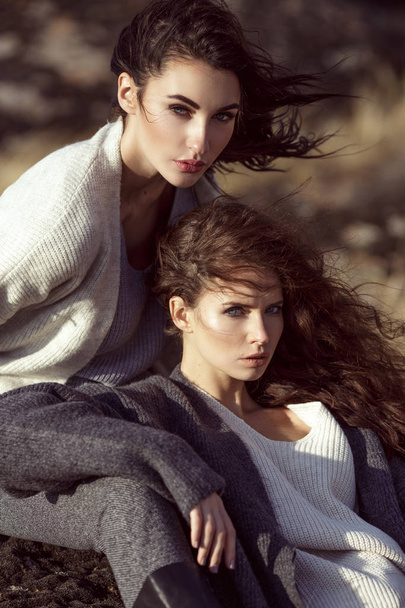 Outdoor fashion portrait of two beautiful stylish ladies in tren - Photo, image