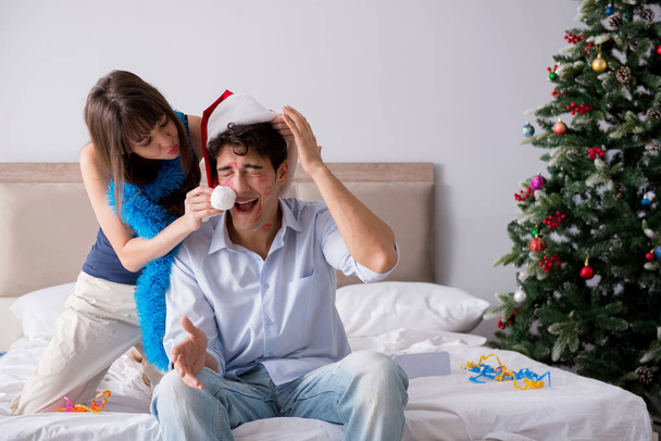 Young happy family celebrating christmas in bed - Photo, Image