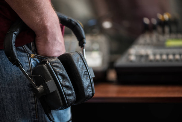 silhouette of a man holding headphones in radio studios - Photo, Image