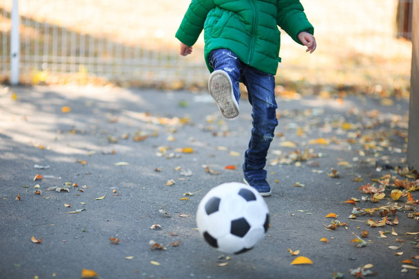 Boy playing with a ball in the autumn on the street - Foto, Imagem