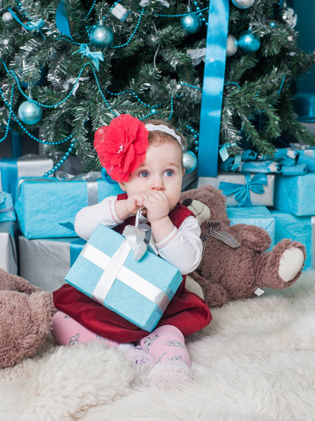 Little girl near Christmas tree with gifts - Fotografie, Obrázek