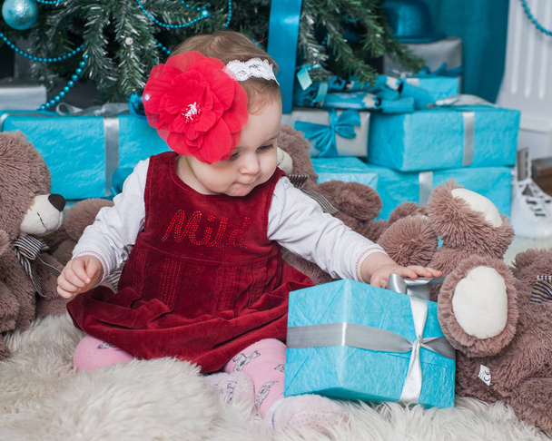 Little girl near Christmas tree with gifts - Valokuva, kuva