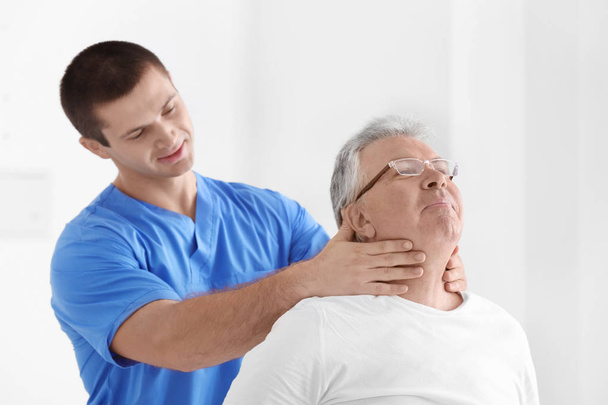 Physiotherapist working with senior patient in modern clinic - 写真・画像
