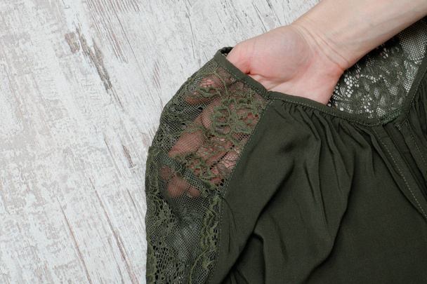 Onderdeel van groene lace blouse aan een vrouwelijke kant. Close-up. Modieuze concept. - Foto, afbeelding