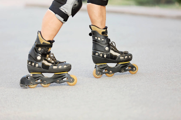 Legs of young man on roller skates - 写真・画像