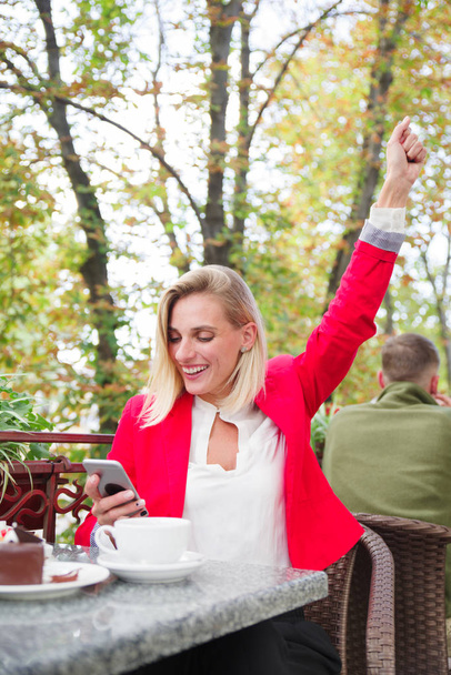 The businesswoman at the cafe ordered dessert and drinks tea outdoor - Фото, изображение