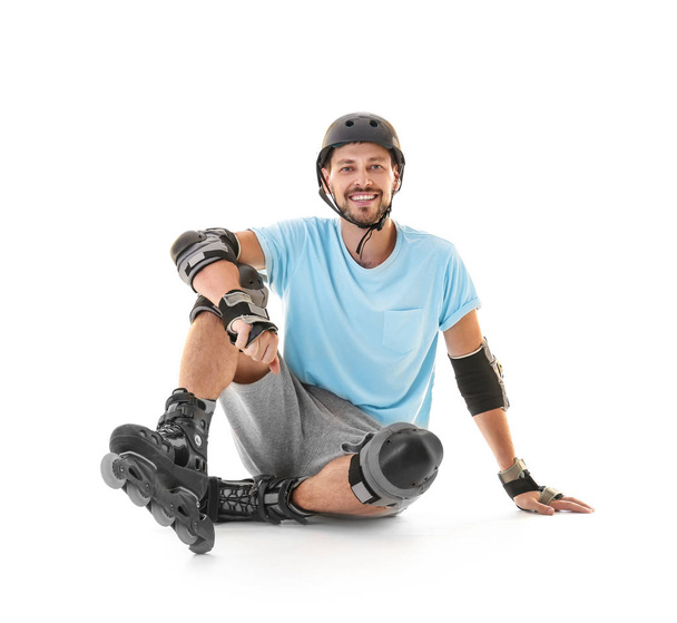 Handsome man with roller skates against white background - Φωτογραφία, εικόνα