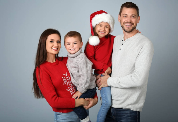 Happy family in Christmas mood on light background - Φωτογραφία, εικόνα