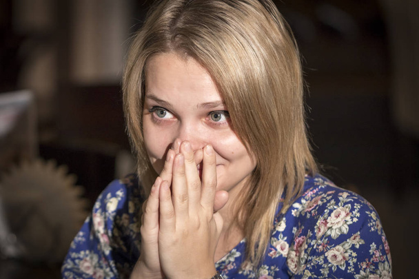 Έκπληκτη νεαρή γυναίκα καλύπτει το στόμα της με τα χέρια - Φωτογραφία, εικόνα