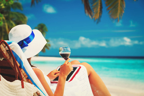 woman with touch pad drinking wine on beach - Foto, Bild
