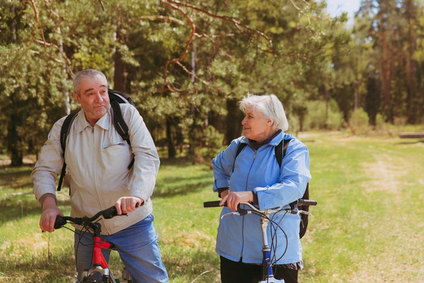Vanhempi pari ratsastus polkupyörää luonnossa
 - Valokuva, kuva