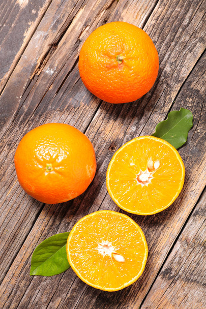 sliced oranges on wooden table - Φωτογραφία, εικόνα