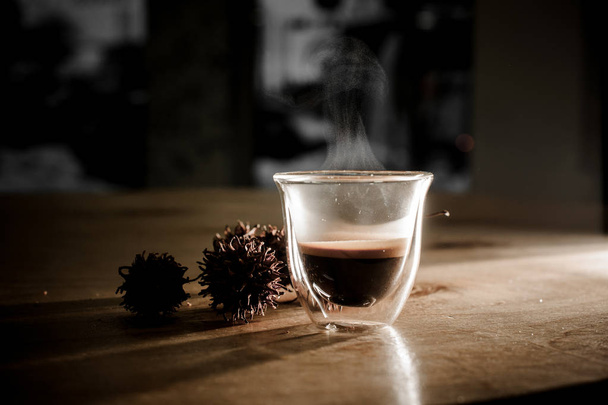 Glass cup of hot coffee with steam from it - Foto, imagen