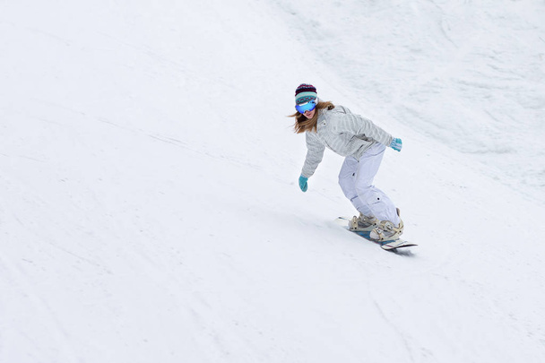 Female snowboarder rocking the slopes in winter - Photo, image