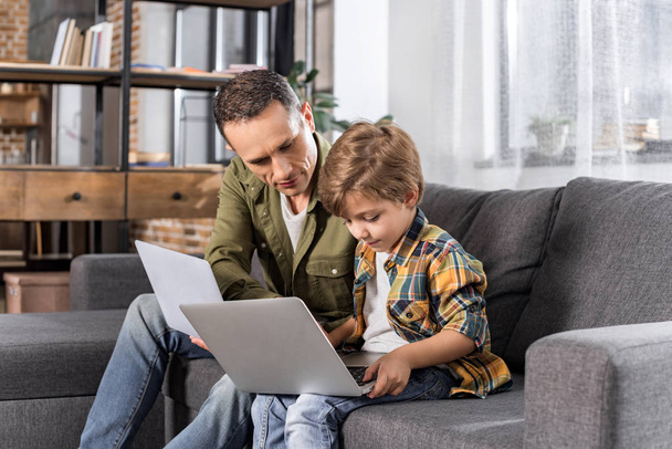 padre e figlio utilizzando computer portatili
 - Foto, immagini
