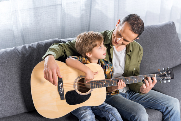 Padre e hijo tocando juntos la guitarra
 - Foto, imagen