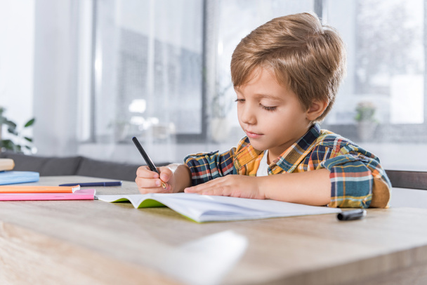 little schoolboy doing homework - Фото, изображение