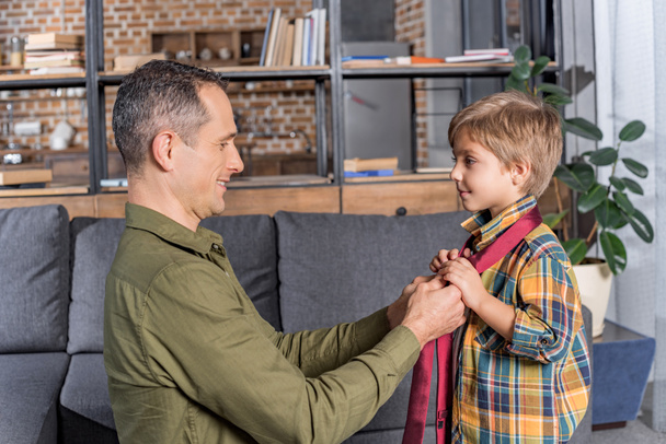 padre enseñando hijo a atar corbata
 - Foto, Imagen