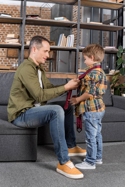 father teaching son to tie necktie - Foto, Bild