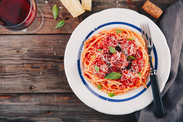 Pasta de espaguetis con albóndigas, salsa de tomate y queso parmesano
 - Foto, imagen